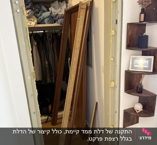 דלת עץ מפורקת ליד ארון בגדים